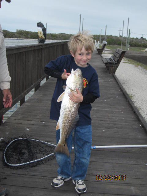 Alex, Board Member, Bob Brumby\'s grandson at the hatchery fish pond,